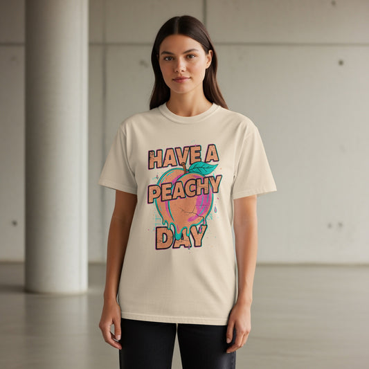 Woman wearing a beige t-shirt with "HAVE A PEACHY DAY" text and graphic.