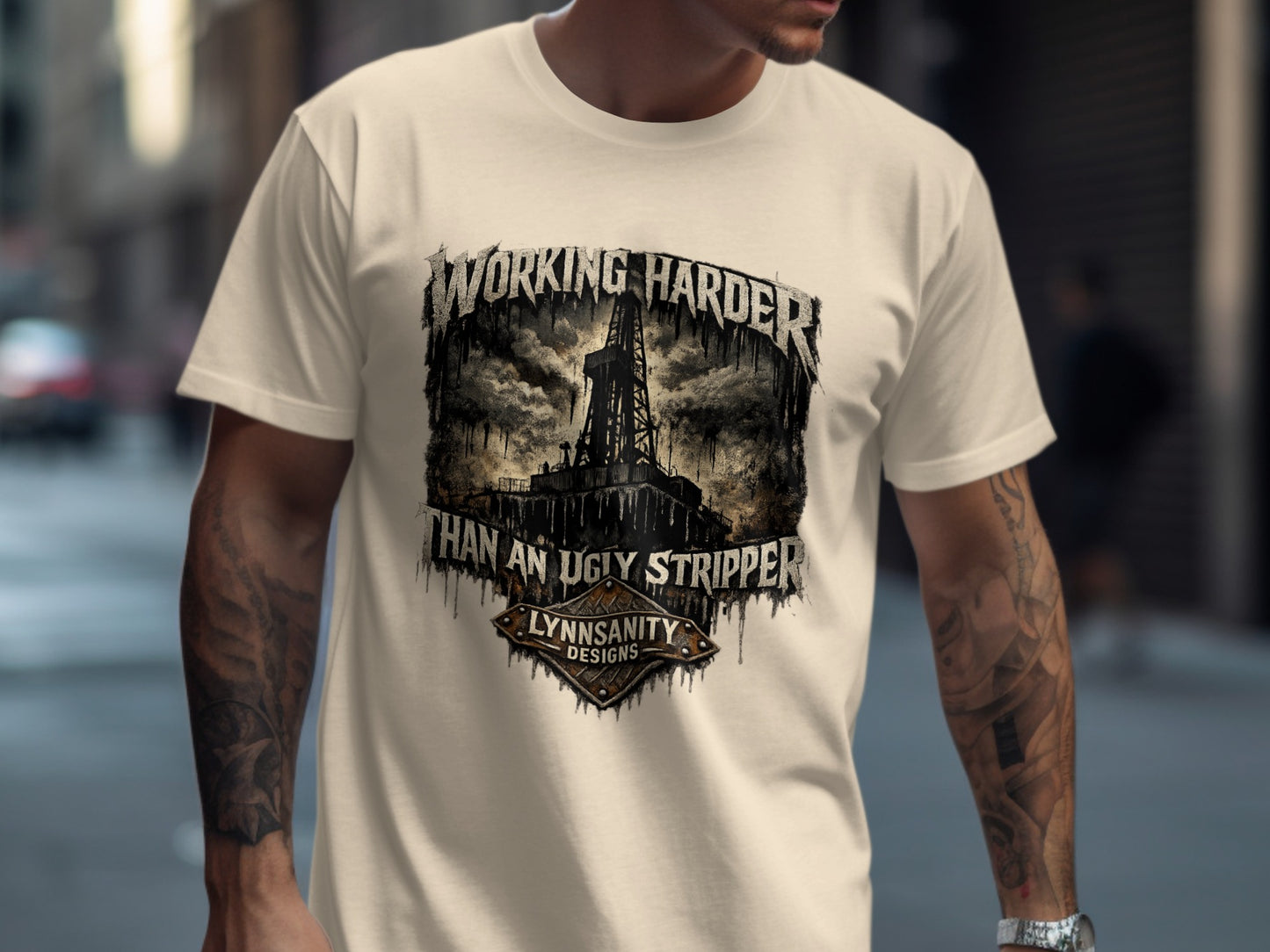 Cream t-shirt with "WORKING HARDER THAN AN UGLY STRIPPER" graphic.