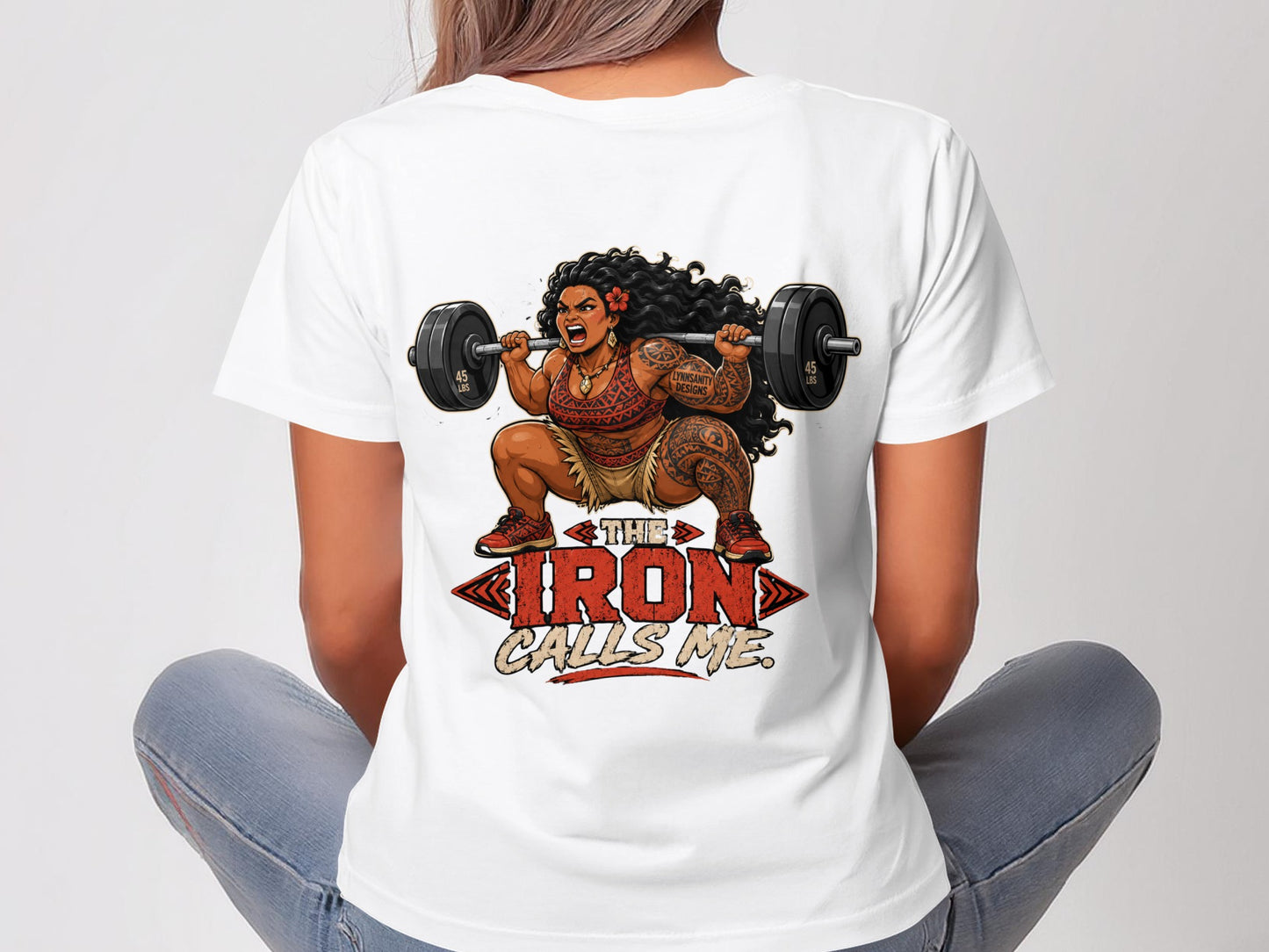Woman in white t-shirt with tattooed arms lifting barbell, text "THE IRON CALLS ME."