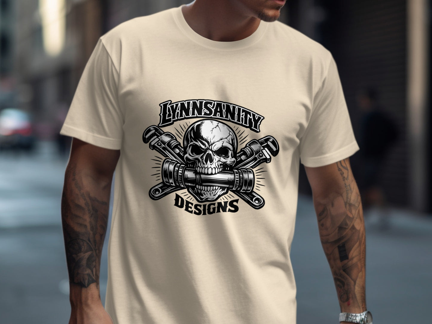 Cream t-shirt with "Lynnsanity Designs" logo featuring a skull and crossed wrenches.