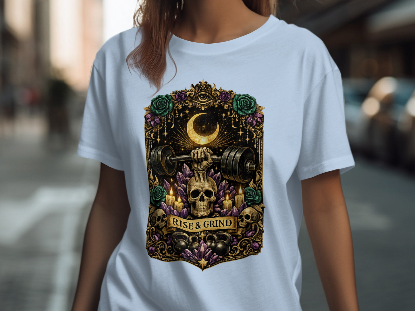 White t-shirt with "Rise & Grind" slogan featuring skulls, weights, and crescent moon.