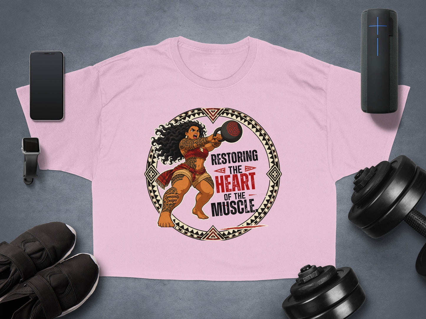 Pink t-shirt with a woman lifting a kettlebell, text "Restoring the heart of the muscle".