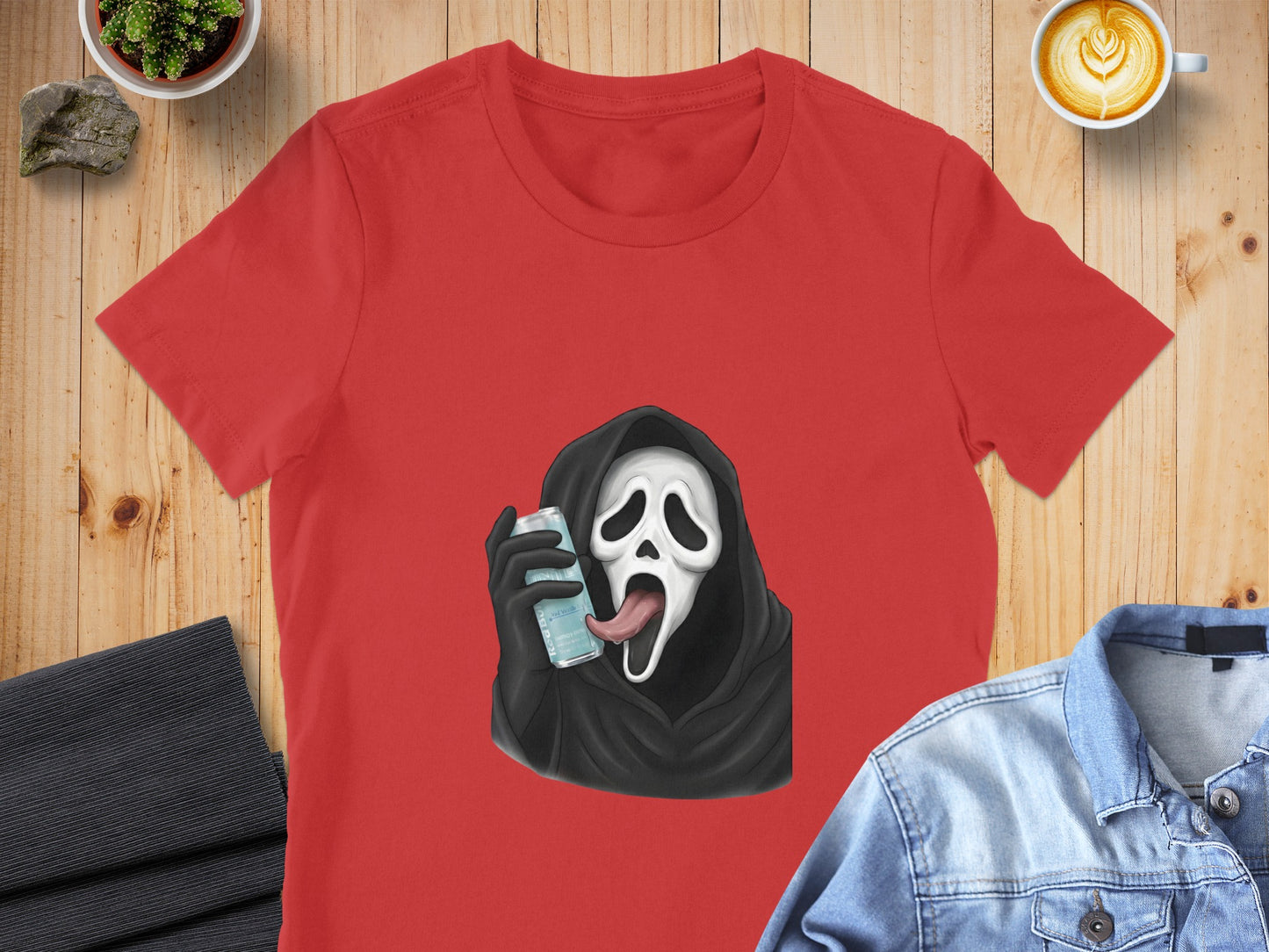 Red t-shirt with a ghost face character holding a can with its tongue out.