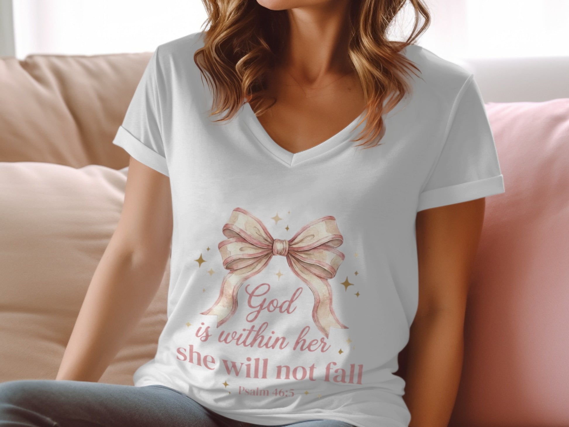 White v-neck t-shirt with pink bow graphic and "God is within her she will not fall" text.