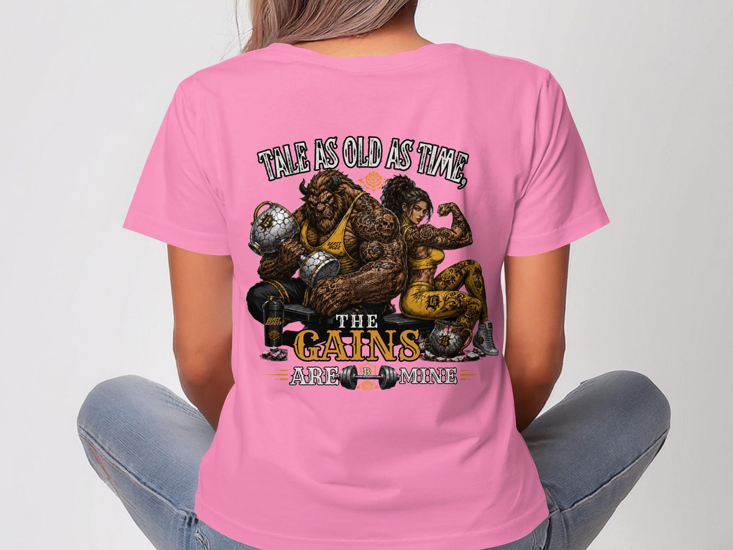 Pink t-shirt with cartoon of muscular man and woman, text "Tale as old as time, the gains are mine."
