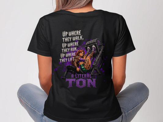 Black t-shirt with purple graphic of a woman on a leg press machine, text "A LITERAL TON".