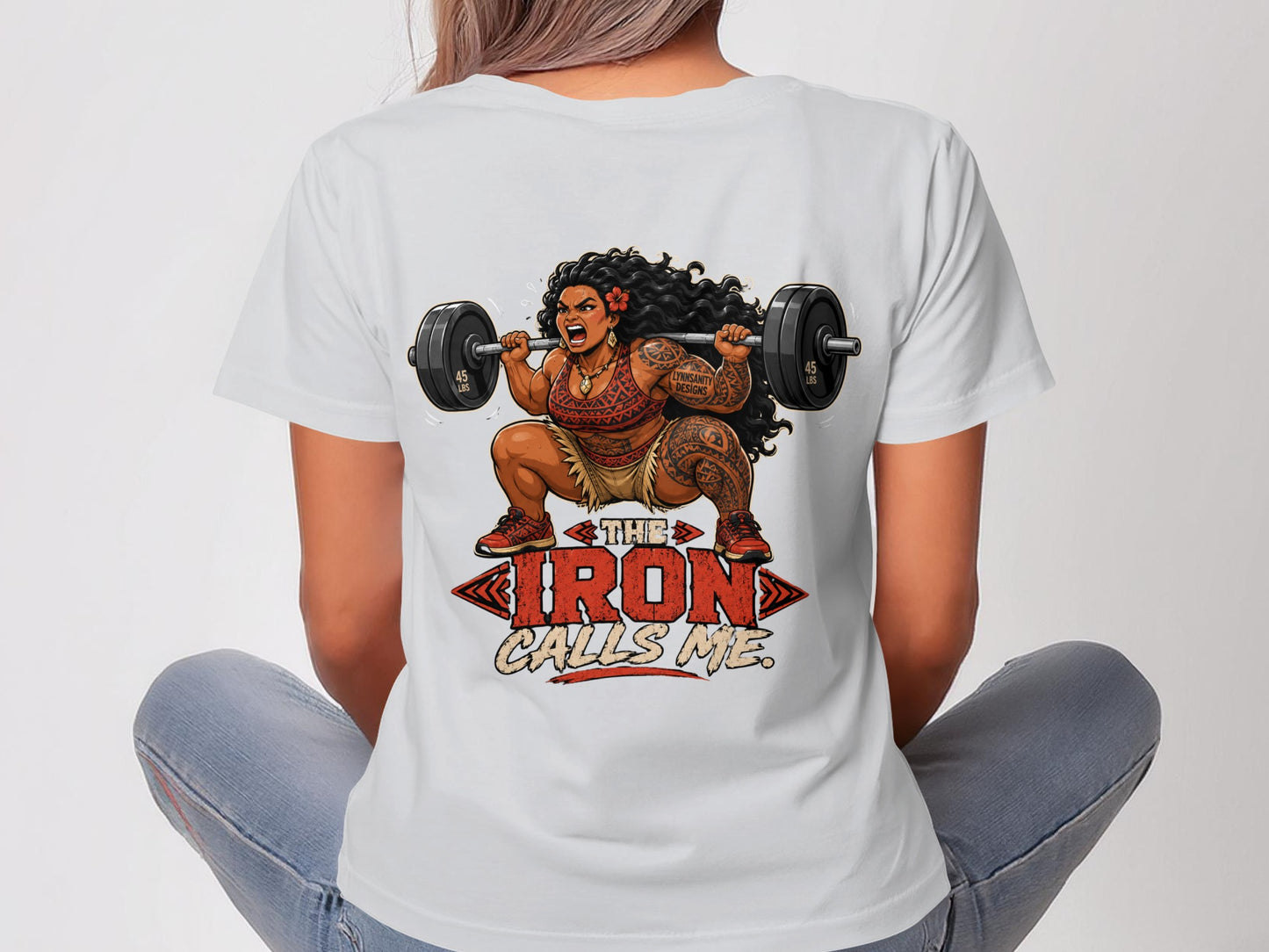 Tattooed woman in athletic wear lifts a barbell, text reads "THE IRON CALLS ME".