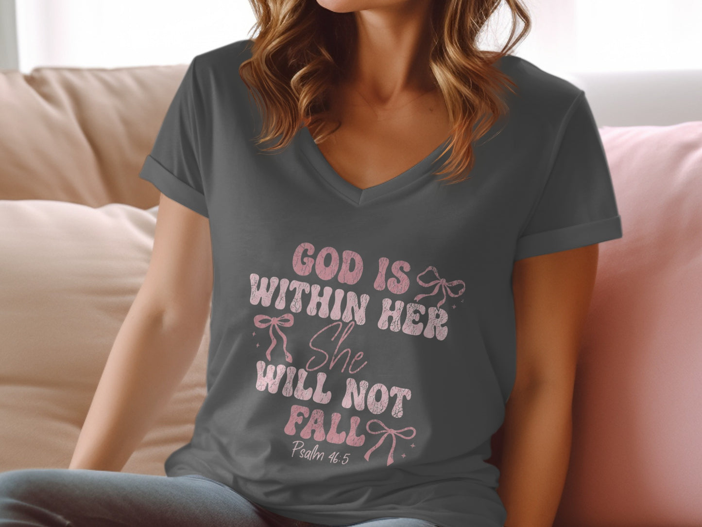Dark gray V-neck t-shirt with pink text and bows, "God is within her She will not fall" Psalm 46:5.