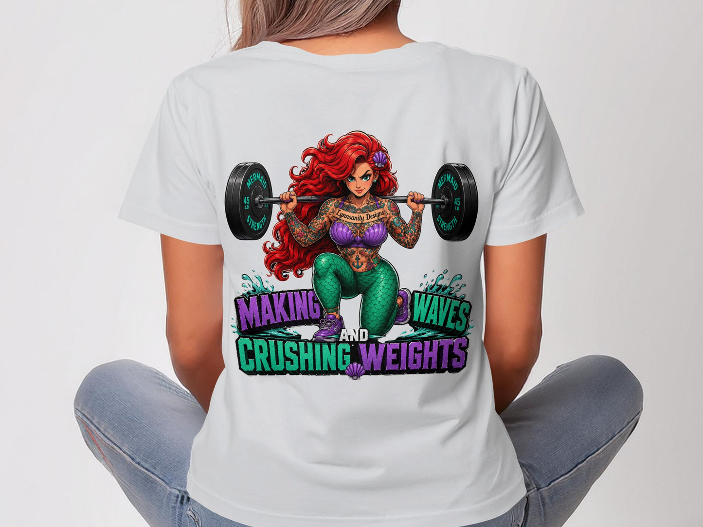 Woman in t-shirt with Ariel lifting weights graphic and text.