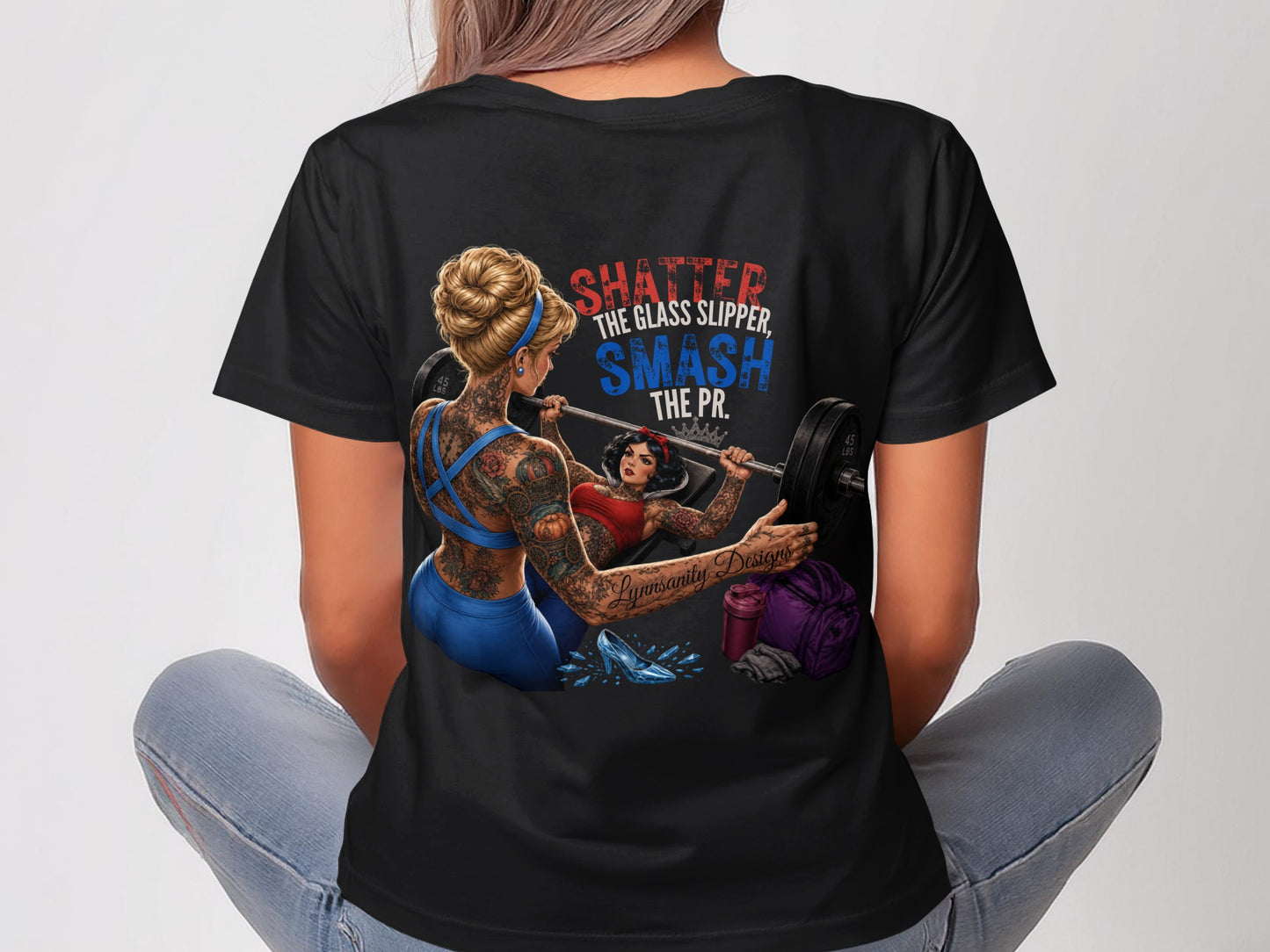 Black t-shirt with "Shatter the glass slipper, smash the PR." slogan and weightlifting graphics.