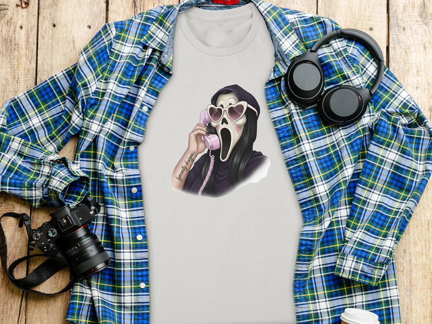 Ghostface from Scream on a phone, wearing heart sunglasses and a t-shirt.