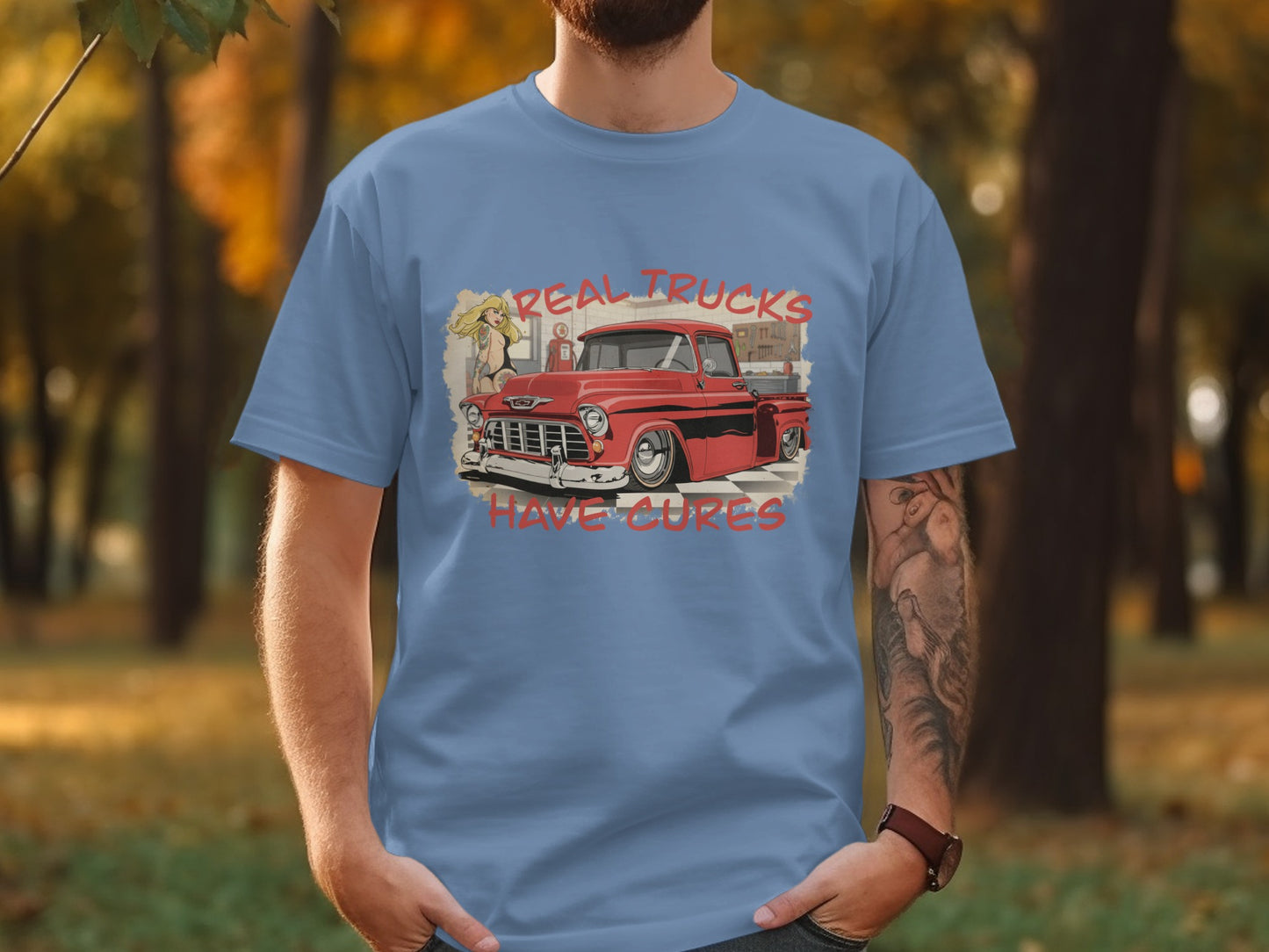 Blue t-shirt with graphic of red vintage truck and text "REAL TRUCKS HAVE CURES".