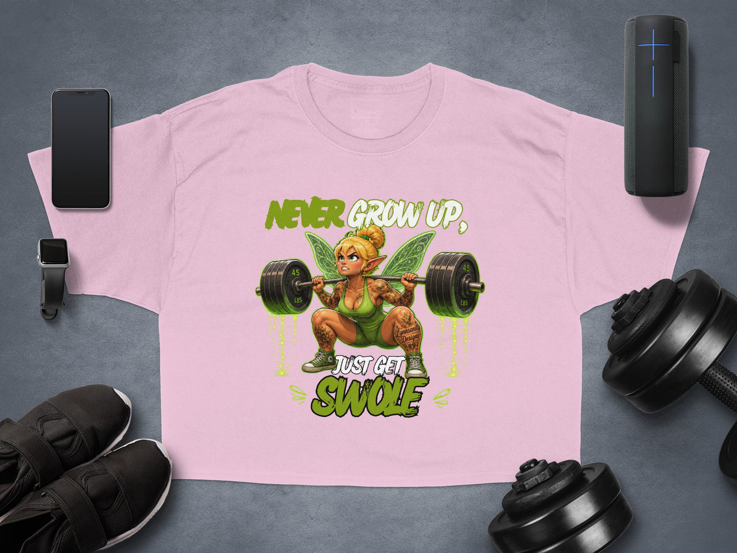 Pink t-shirt with fairy lifting weights, text reads "Never Grow Up, Just Get Swole".