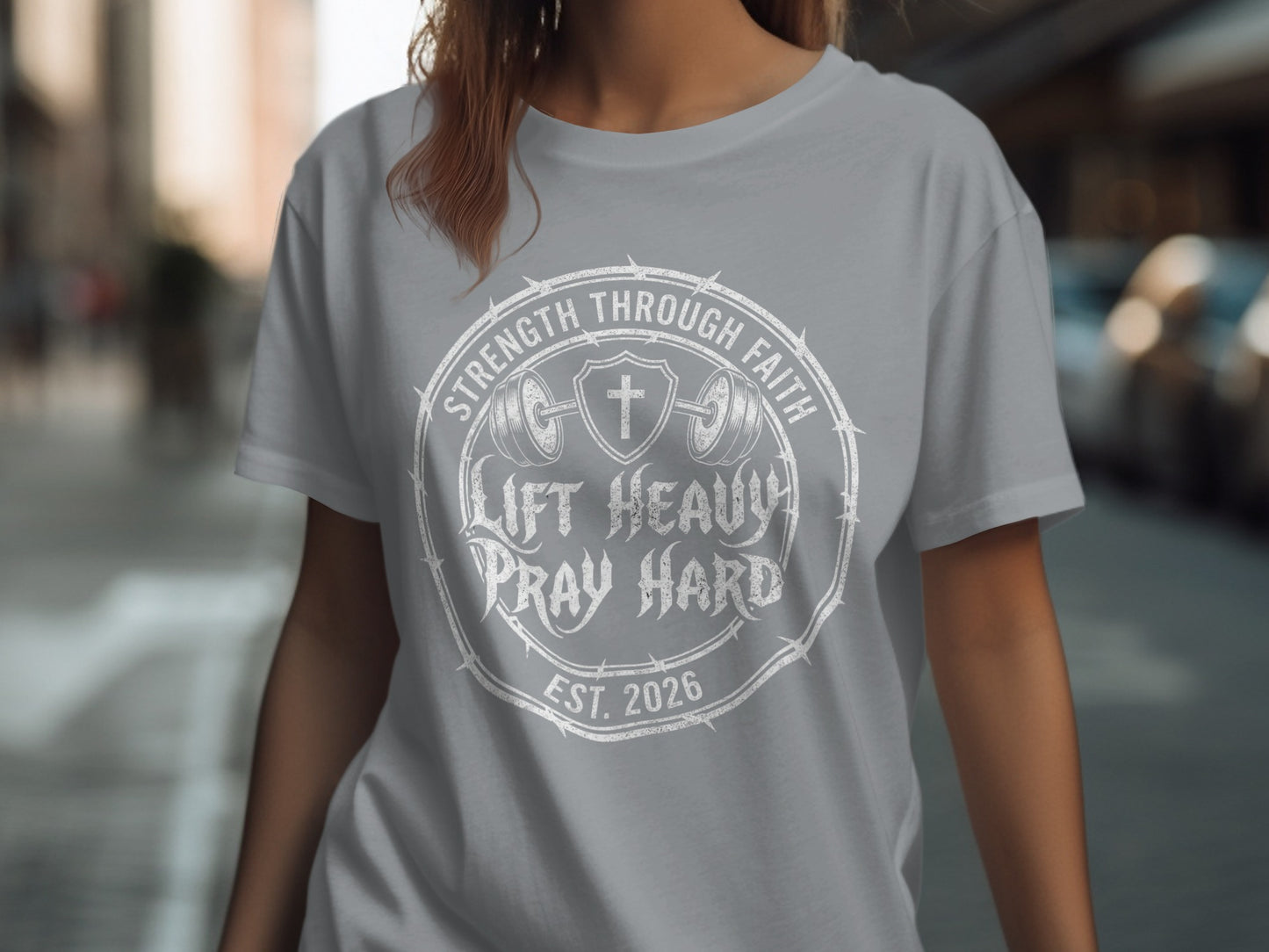 Grey t-shirt with "Lift Heavy Pray Hard" text and barbell cross design.