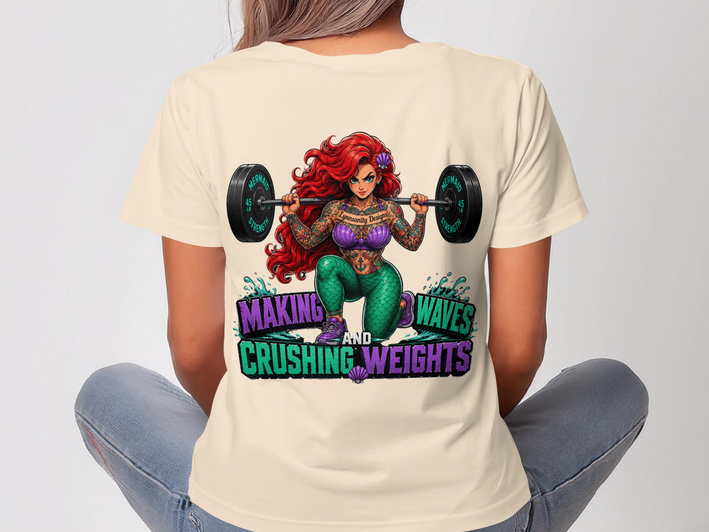 Ariel tattooed and lifting weights with inspirational text.