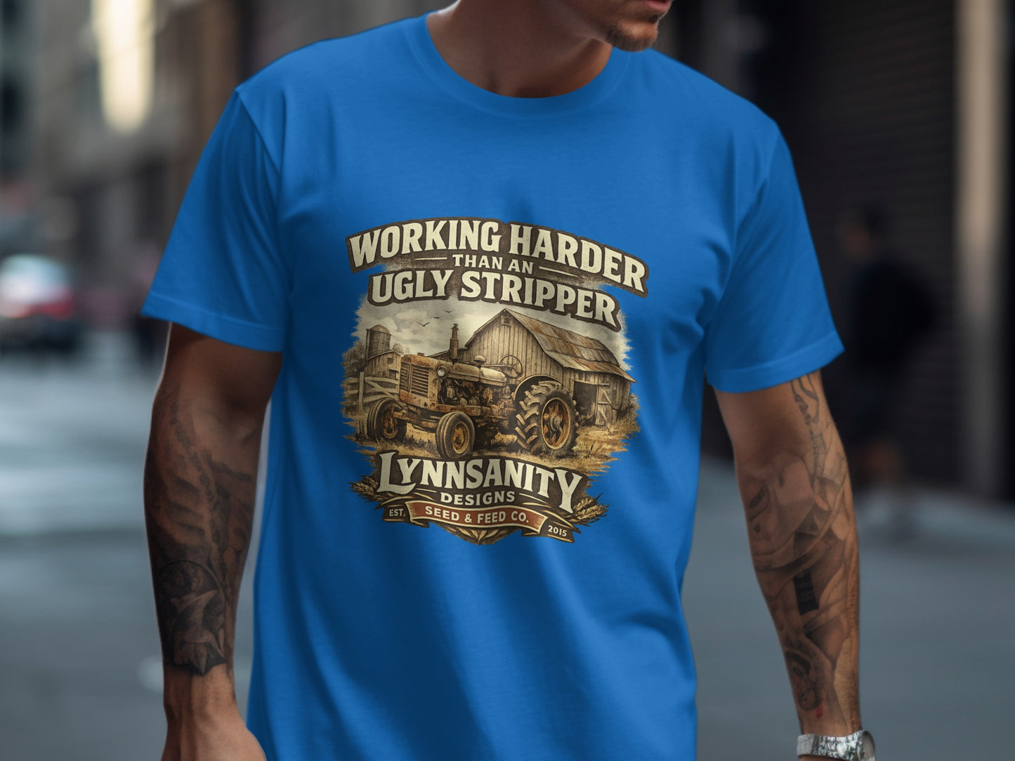 T-shirt with vintage tractor and barn graphic, "Working Harder Than An Ugly Stripper" text.