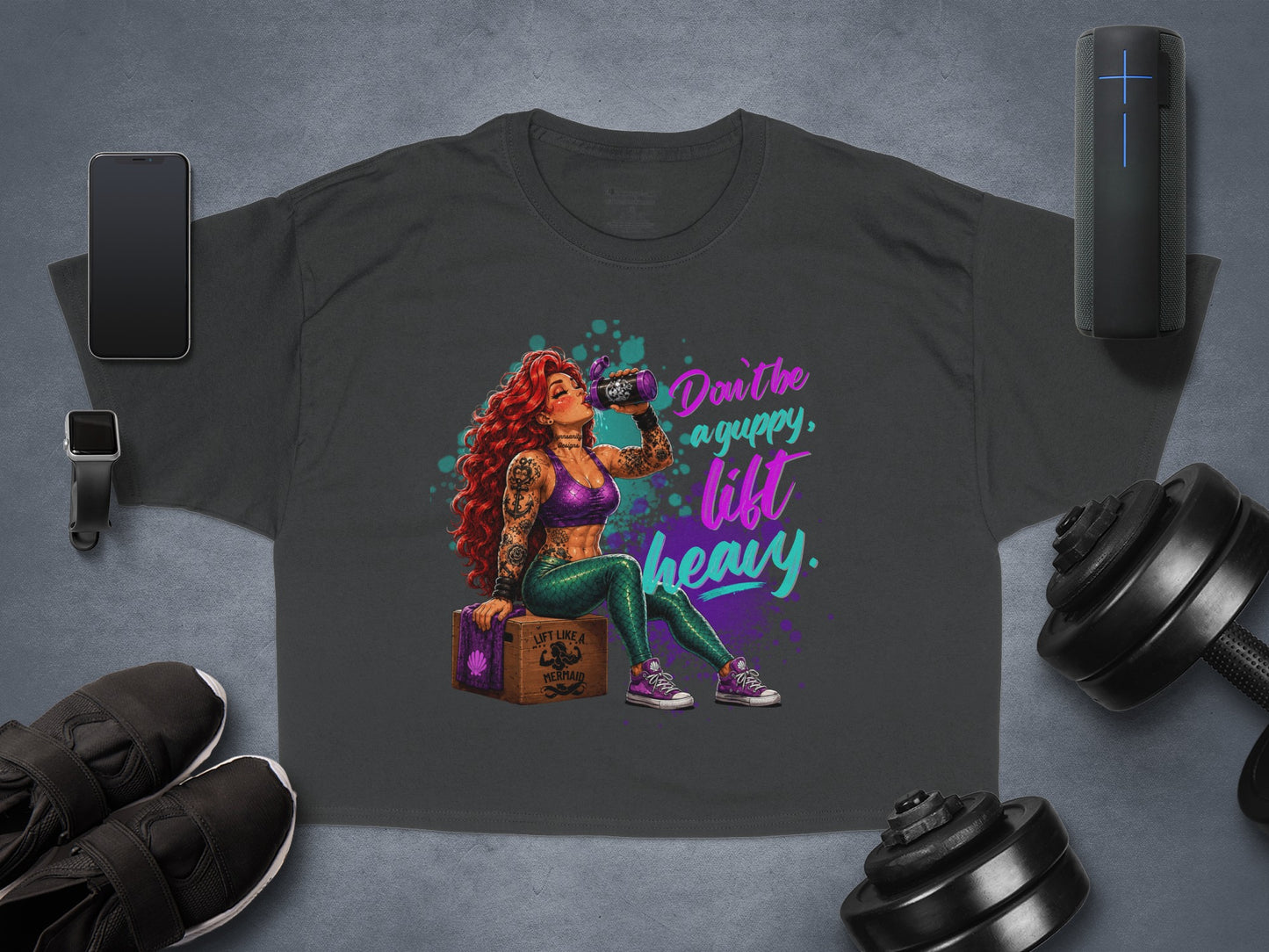 Dark t-shirt with "Don't be a guppy, lift heavy" graphic of a mermaid.