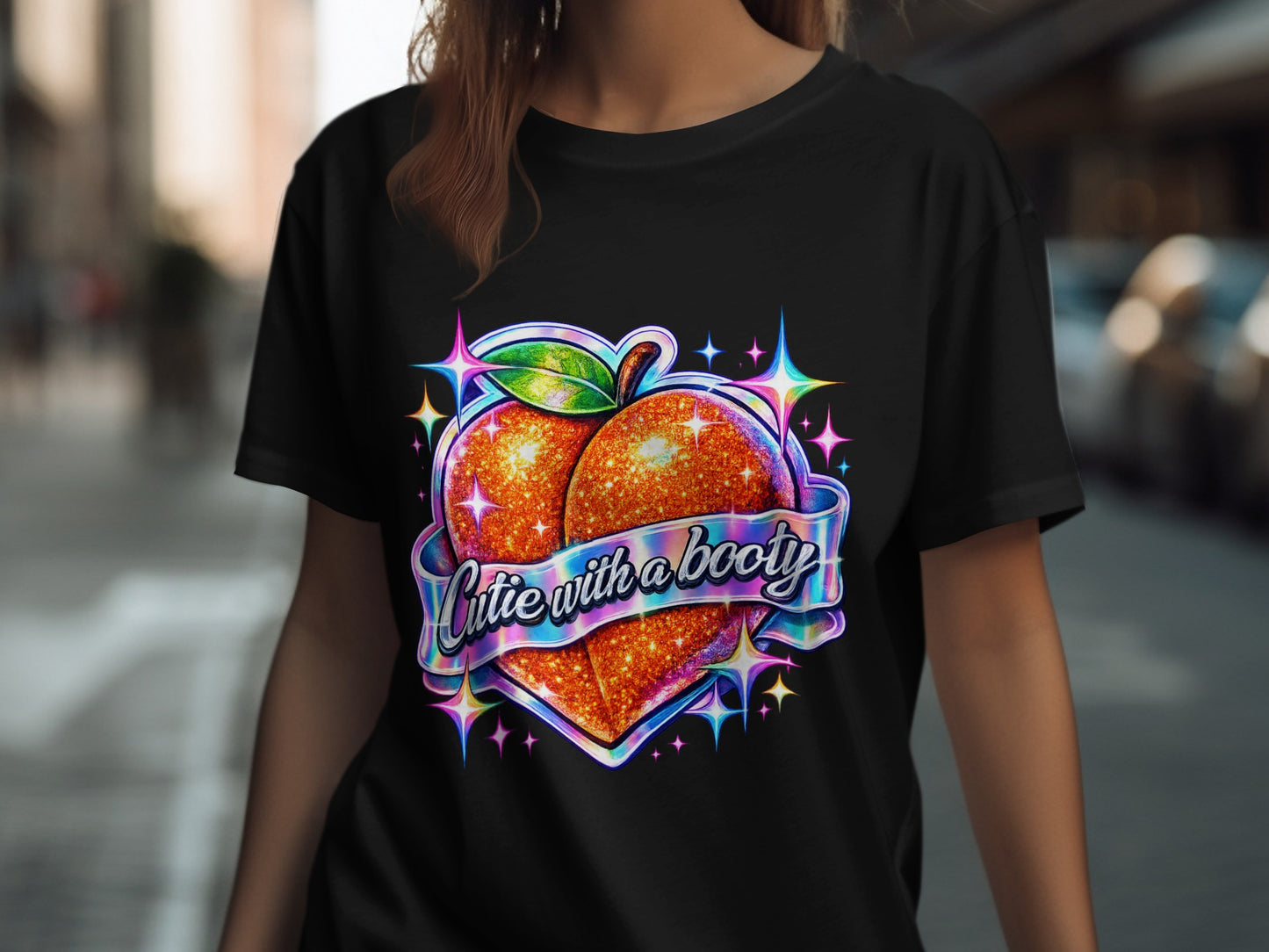 Glittery peach graphic with "Cutie with a booty" text on a black t-shirt.