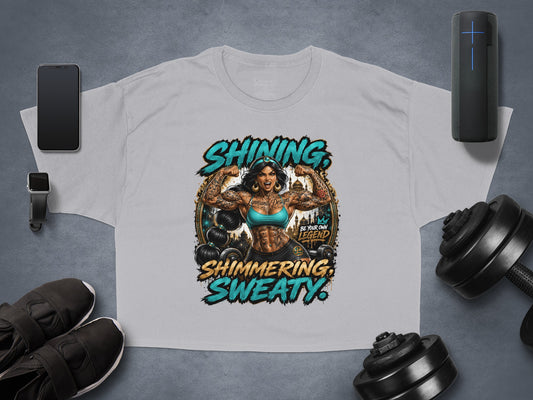 Grey cropped t-shirt with "Shining, Shimmering, Sweaty" text and a muscular female figure.