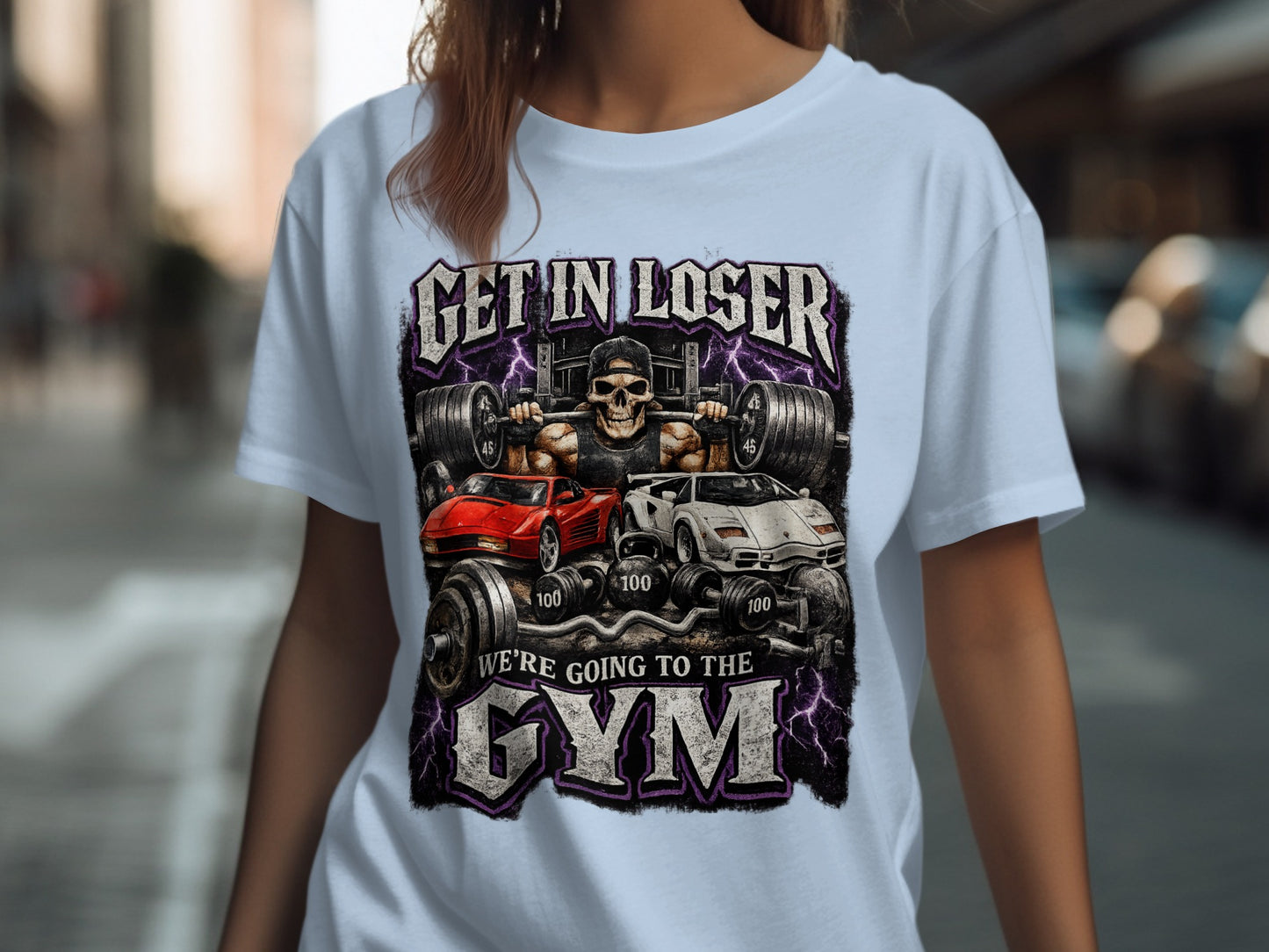T-shirt graphic with skull lifting weights between two sports cars, reads "GET IN LOSER WE'RE GOING TO THE GYM".