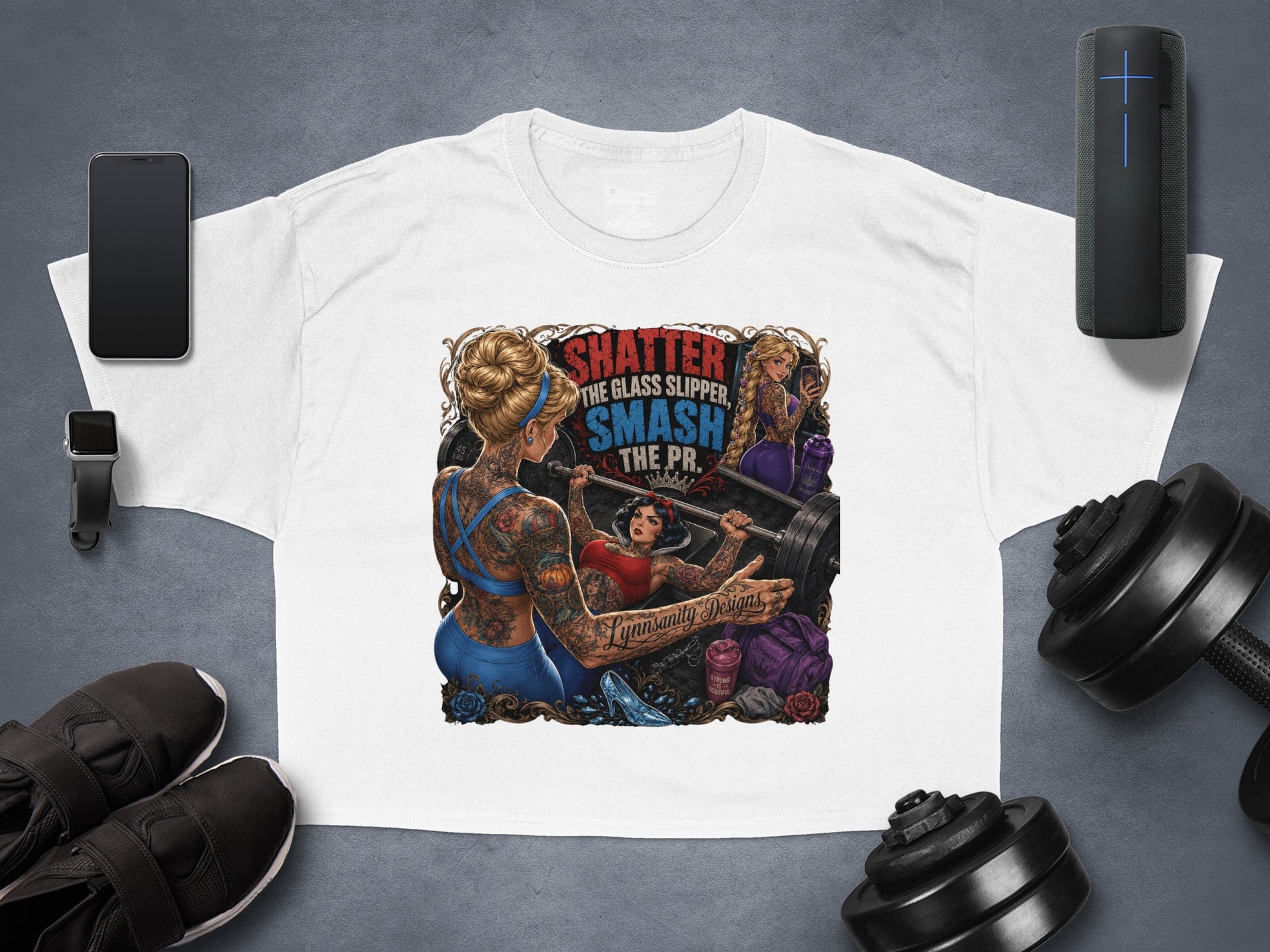 T-shirt featuring a tattooed woman lifting weights with text "SHATTER THE GLASS SLIPPER, SMASH THE PR."