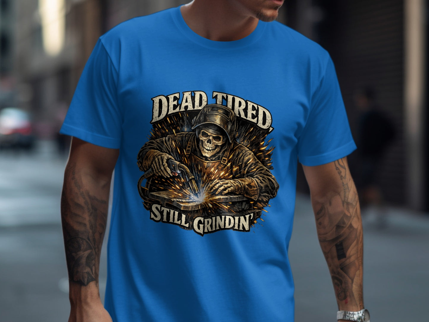 T-shirt with welder graphic and text "Dead Tired Still Grindin'".