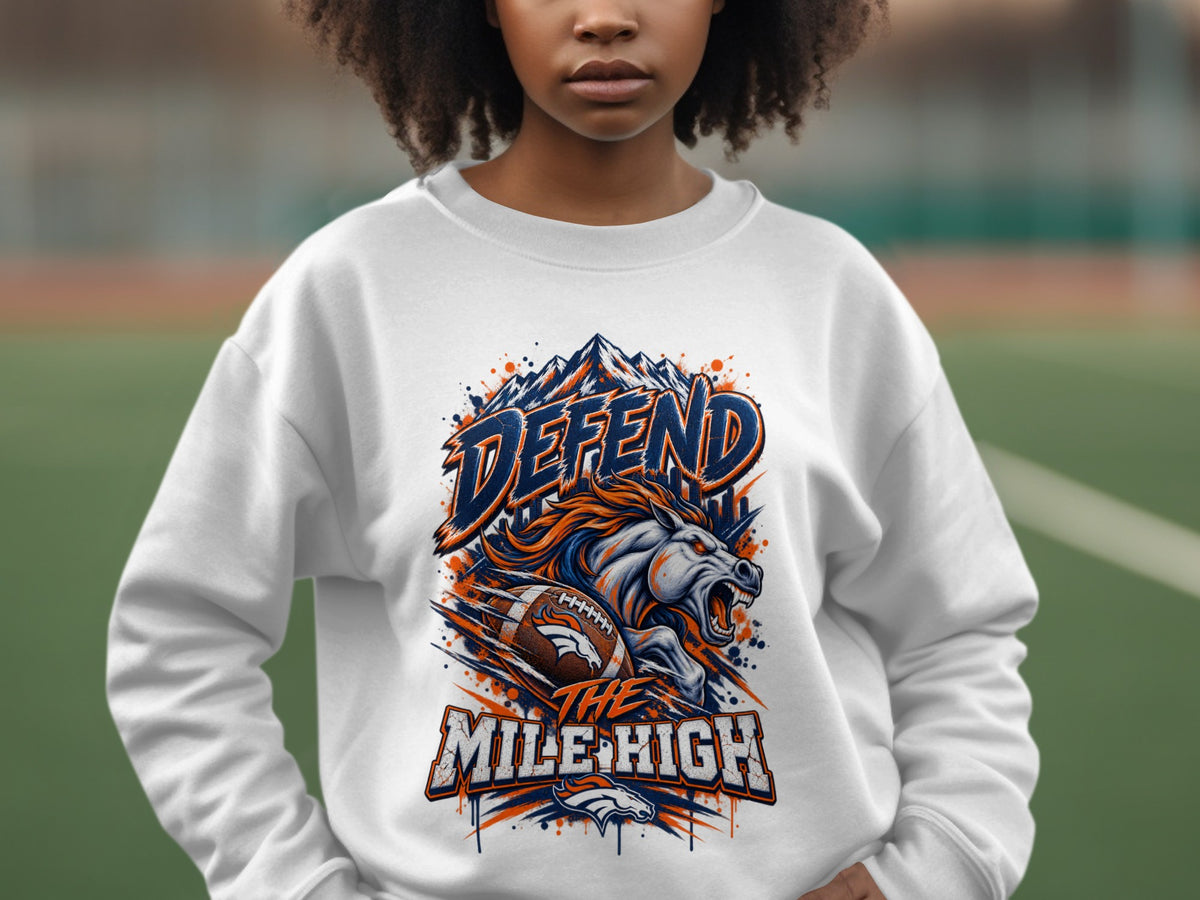 White sweatshirt with "Defend the Mile High" graphic featuring mountains, horse, and football.