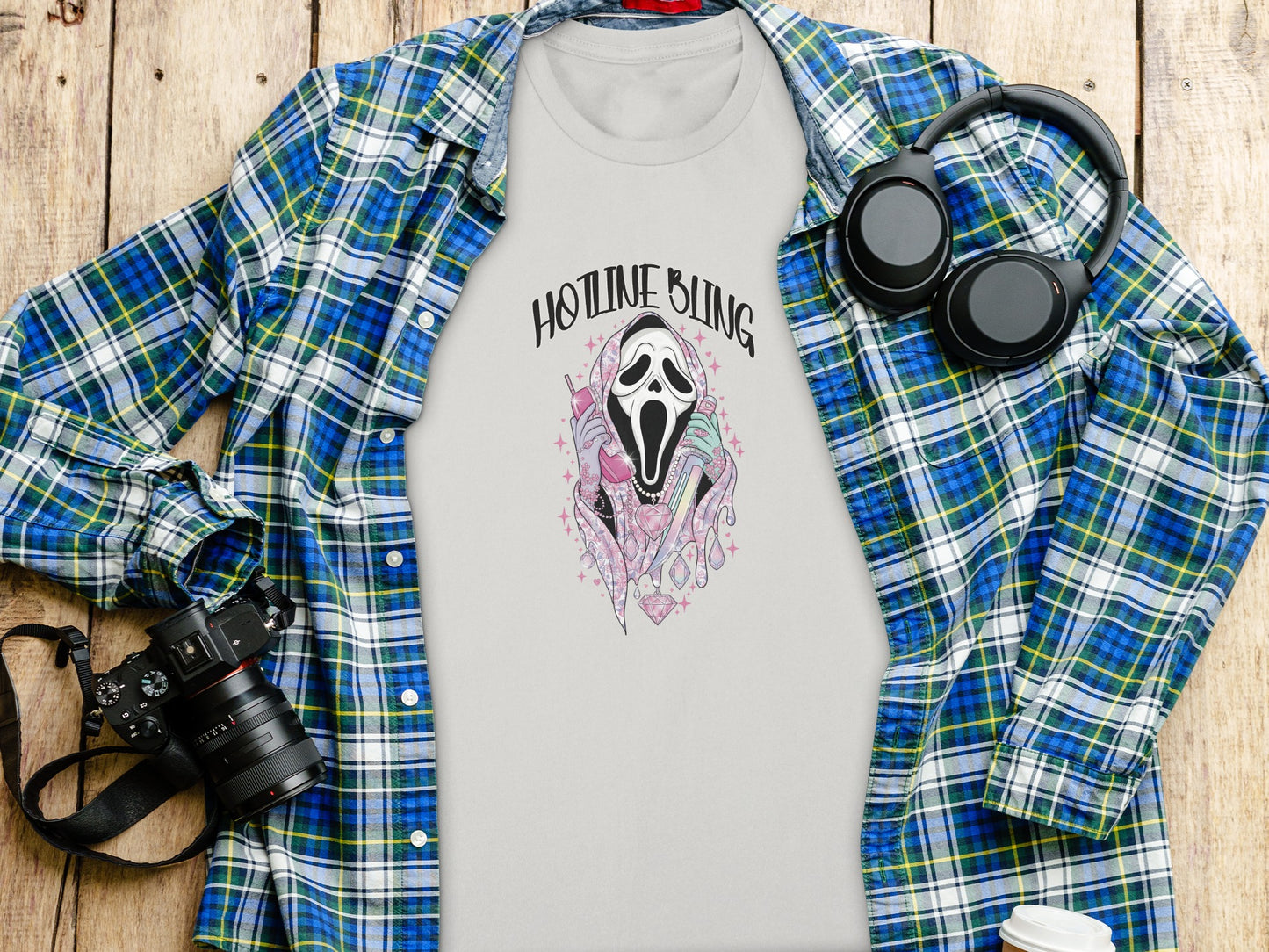 T-shirt with "HOTLINE BLING" ghost graphic, headphones, and camera.