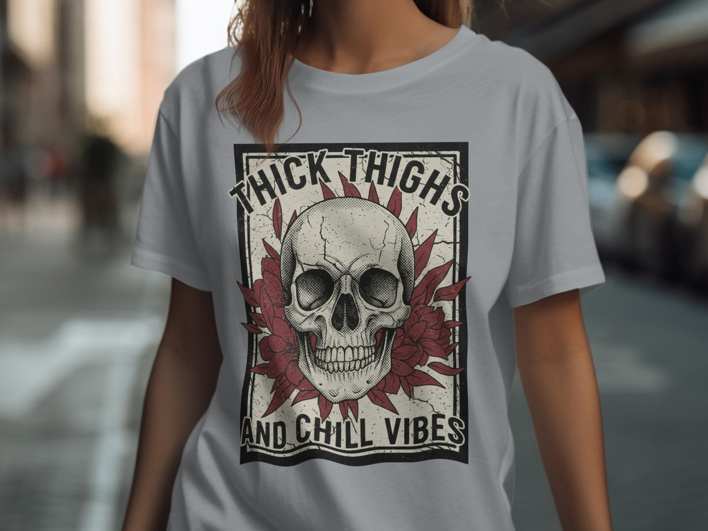 Skull and flowers graphic on a grey t-shirt with "Thick Thighs And Chill Vibes" text.