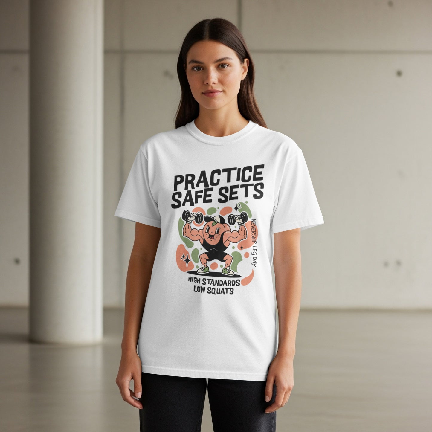 White t-shirt with cartoon man lifting weights and text "PRACTICE SAFE SETS"