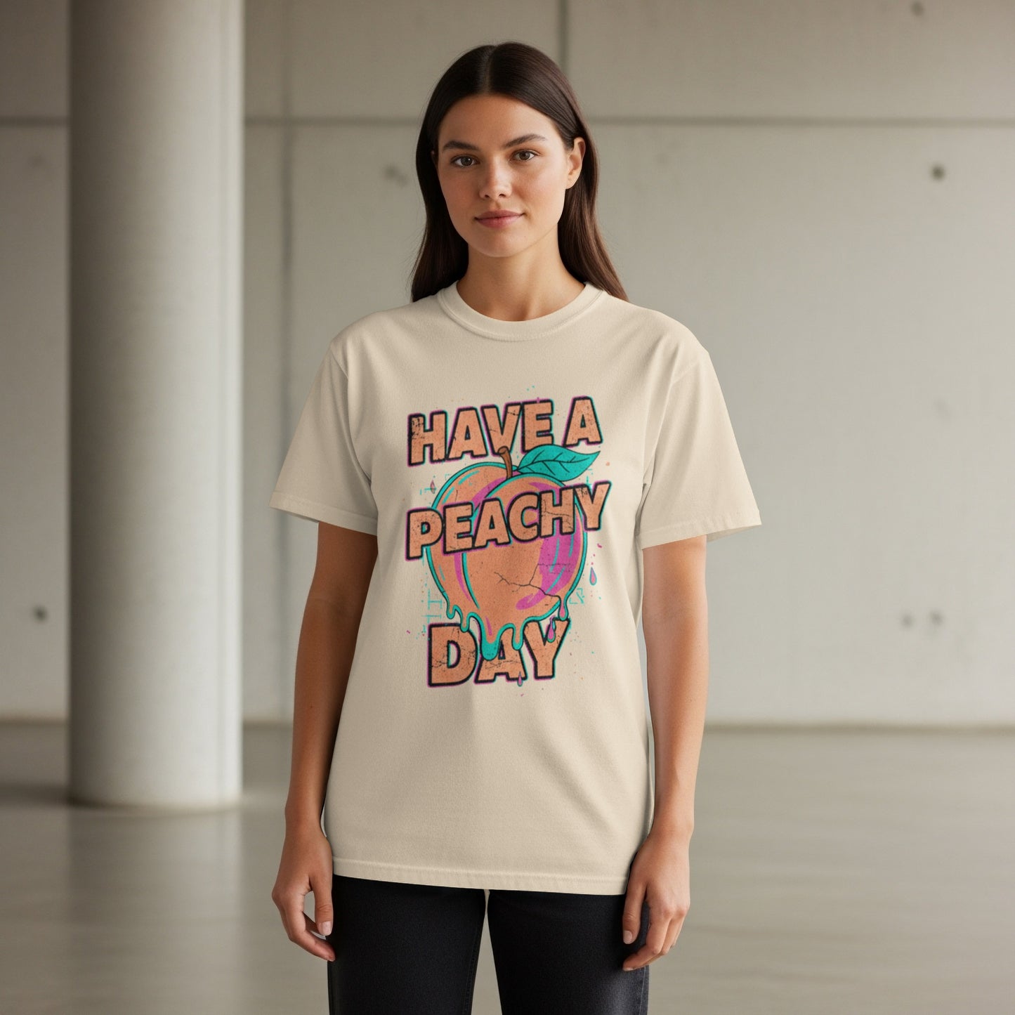 Woman wearing a beige t-shirt with "HAVE A PEACHY DAY" text and graphic.