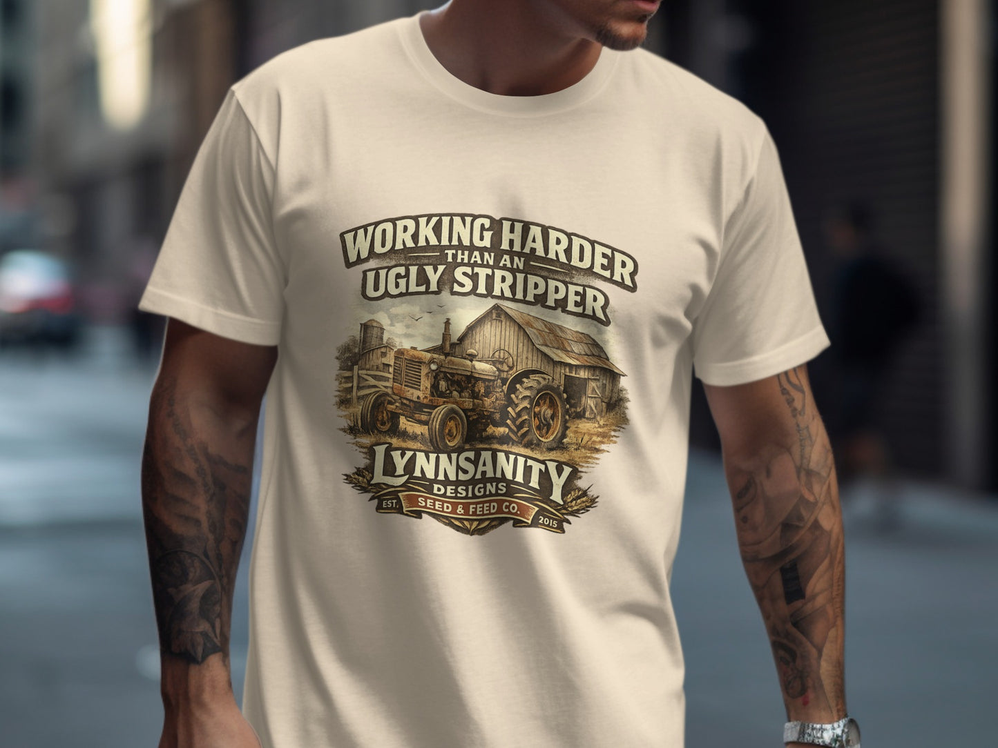 T-shirt with vintage tractor graphic and "Working Harder Than An Ugly Stripper" text.