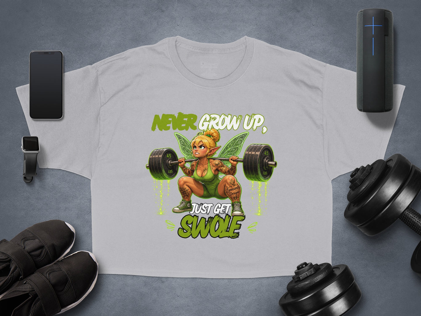 T-shirt graphic featuring a muscular fairy with barbell and text "Never Grow Up, Just Get Swole".