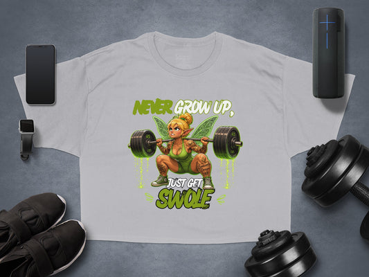 T-shirt graphic featuring a muscular fairy with barbell and text "Never Grow Up, Just Get Swole".