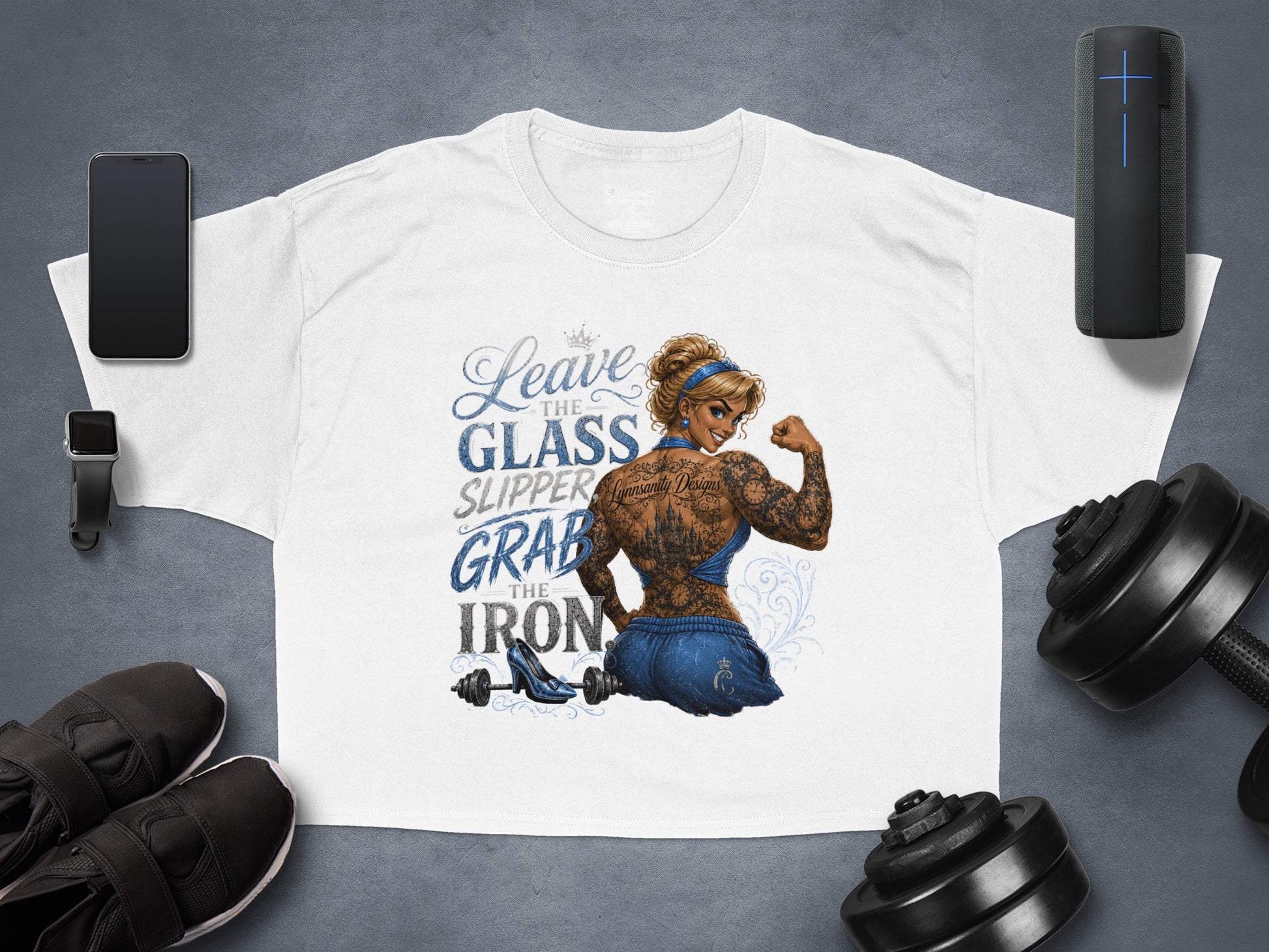 White t-shirt with "Leave the glass slipper, grab the iron" text and tattooed woman illustration.