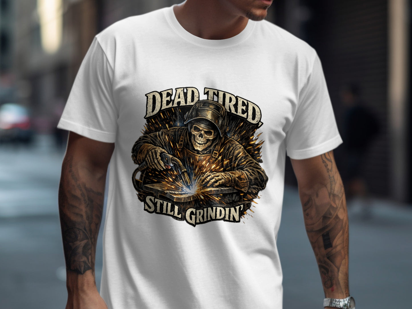 White t-shirt with skull welder graphic and "Dead Tired Still Grindin" text.