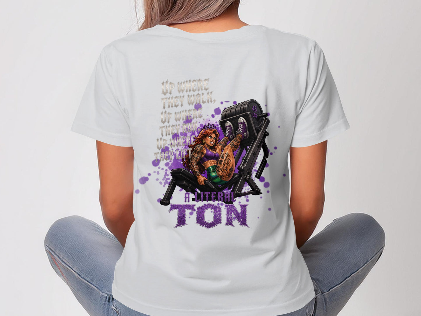 Tattooed woman on weight machine with "A Literal Ton" text.