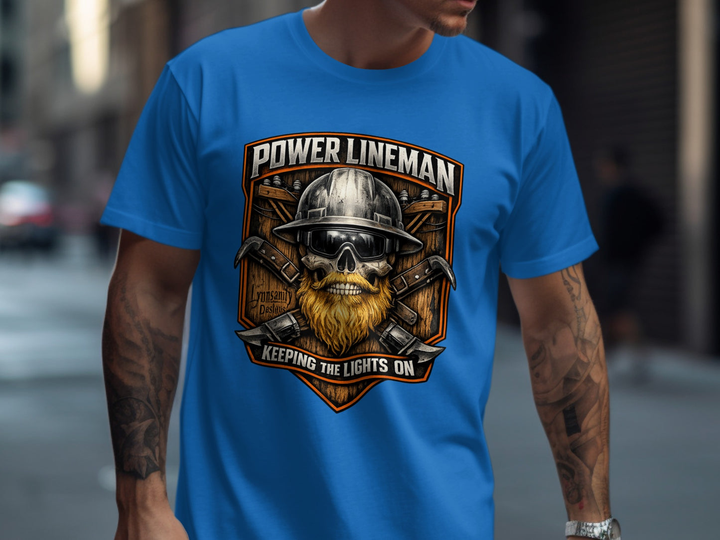Power lineman graphic with helmet, beard, and tools on a blue t-shirt.