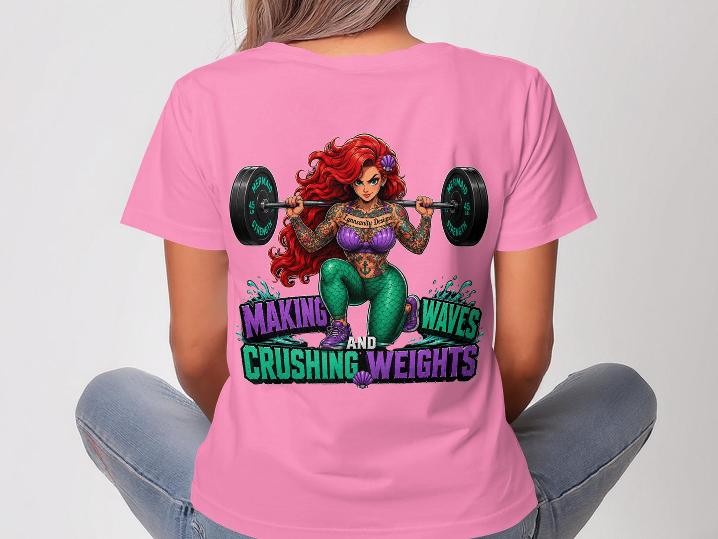 Woman in pink t-shirt with Little Mermaid lifting weights, text "MAKING WAVES AND CRUSHING WEIGHTS".