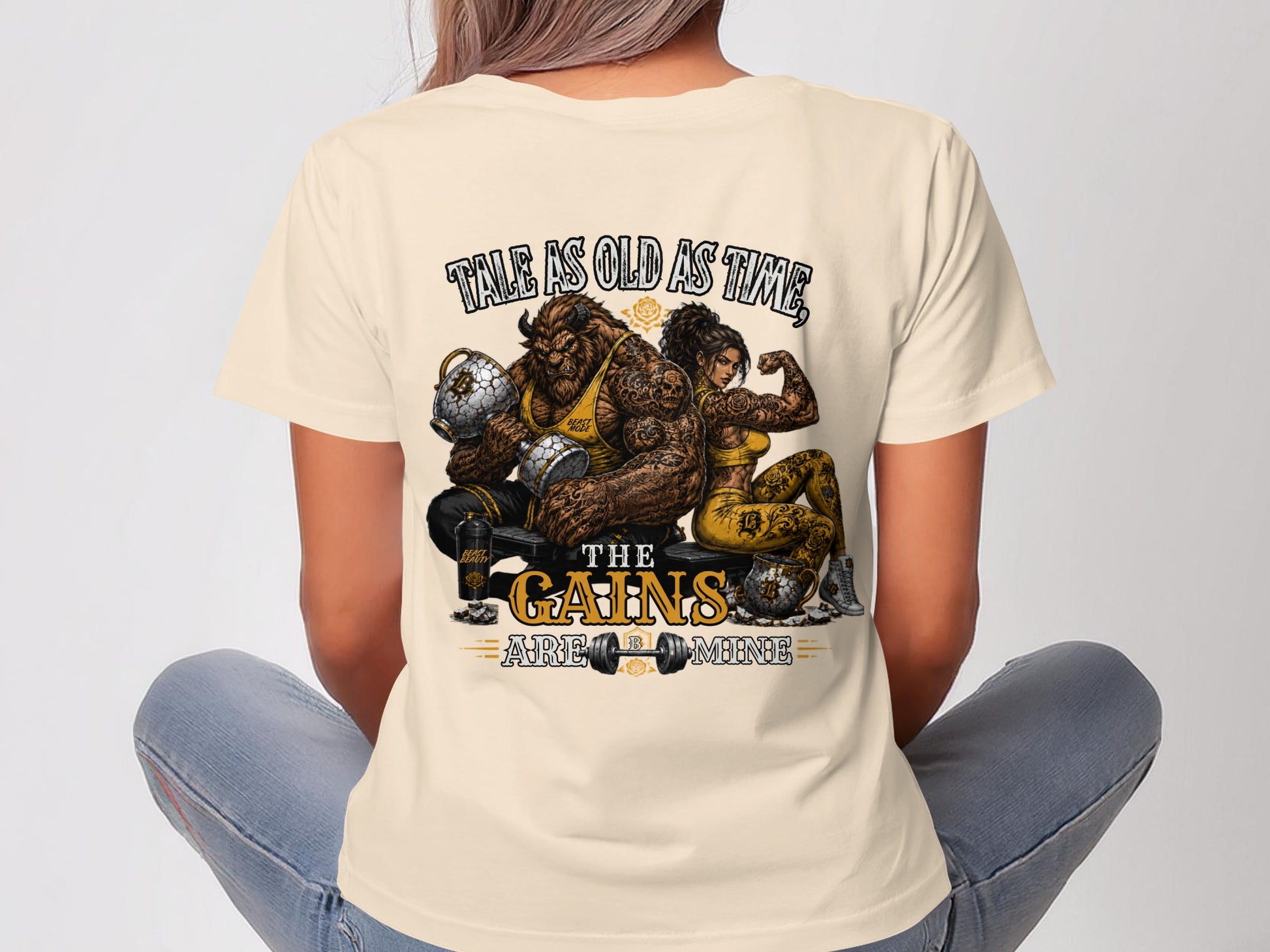 Tale as old as time, the gains are mine graphic on a light tan t-shirt.