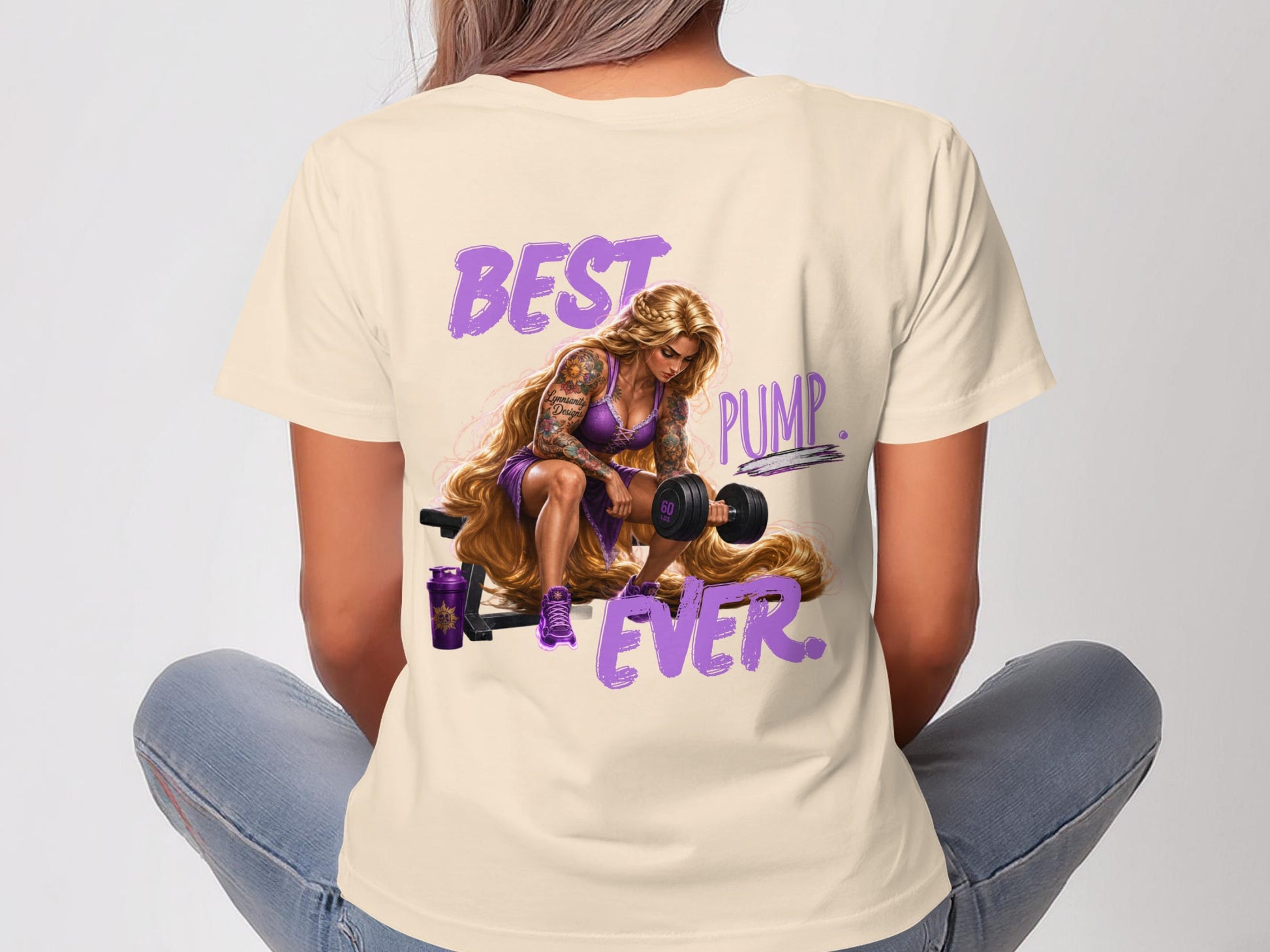 Woman in cream t-shirt with "BEST PUMP EVER" graphic, lifting weights.