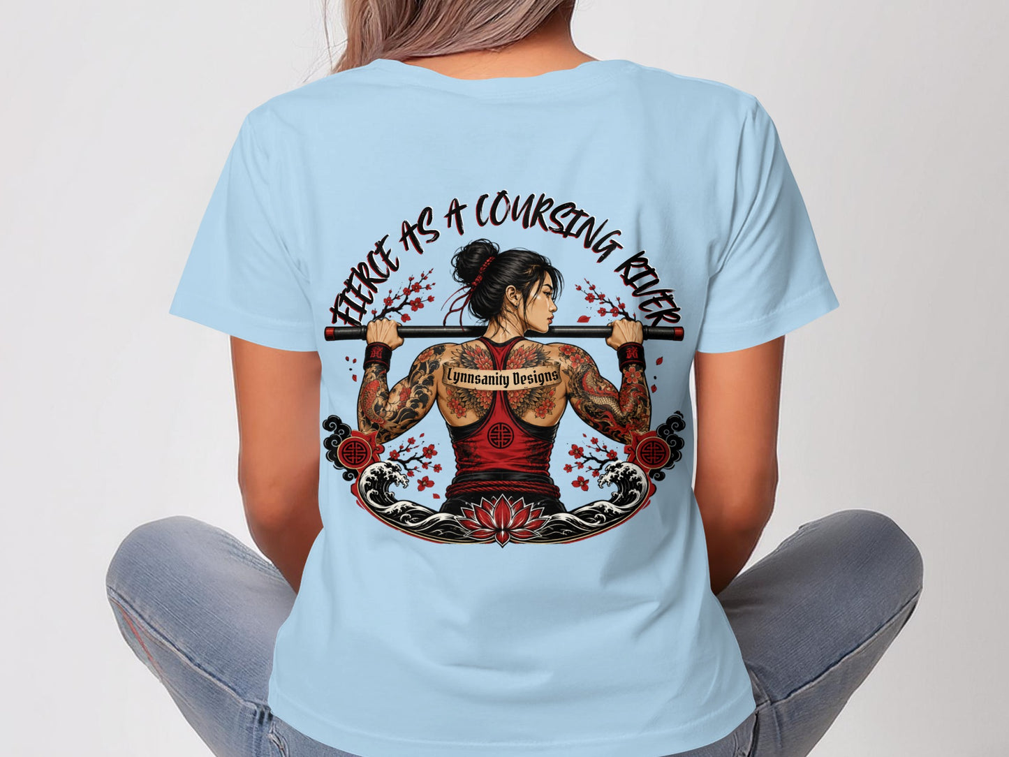 Woman in light blue t-shirt with Japanese-inspired dragon tattoo and floral designs.