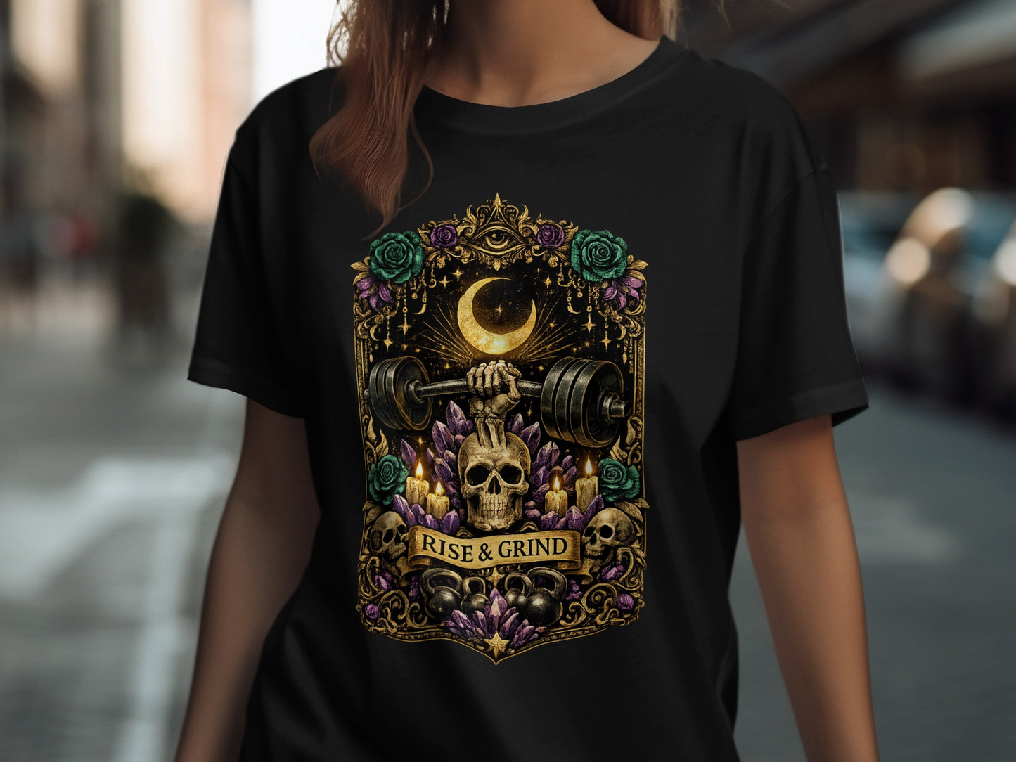 Black t-shirt with barbell, moon, skulls, roses, and crystals; "RISE & GRIND" text.