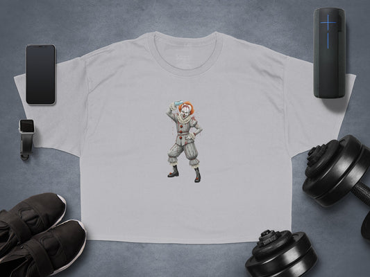 Gray t-shirt with a clown character design, flat lay with gym accessories.