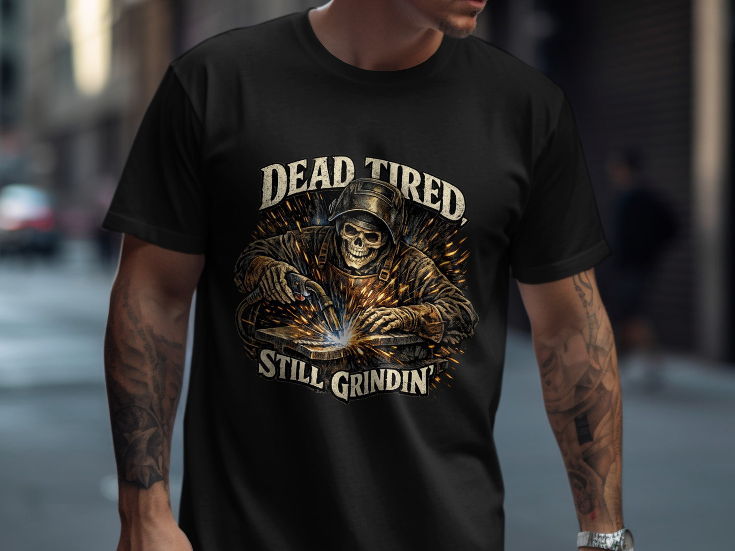 T-shirt with graphic of a welder and text "Dead Tired, Still Grindin'".