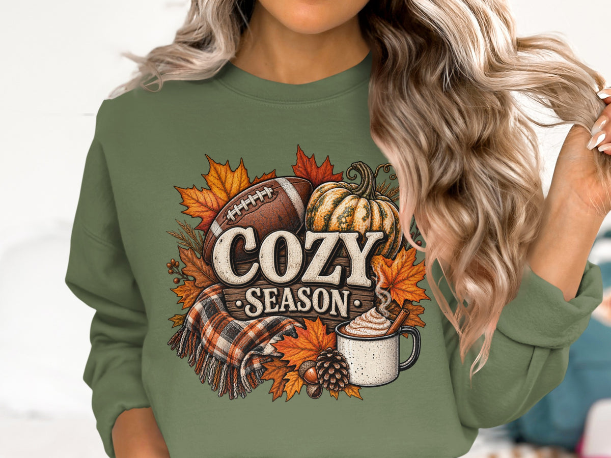 Green sweatshirt with "Cozy Season" graphic featuring football, pumpkin, and fall leaves.