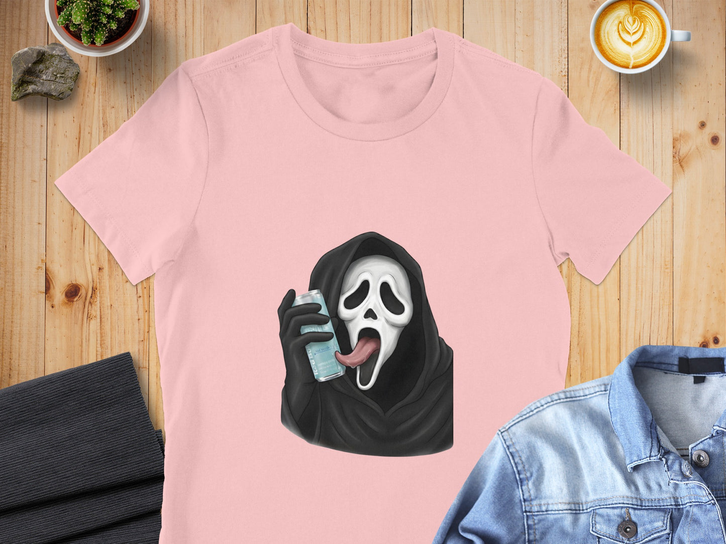 Pink t-shirt with Ghostface character from Scream holding a blue can with tongue sticking out.