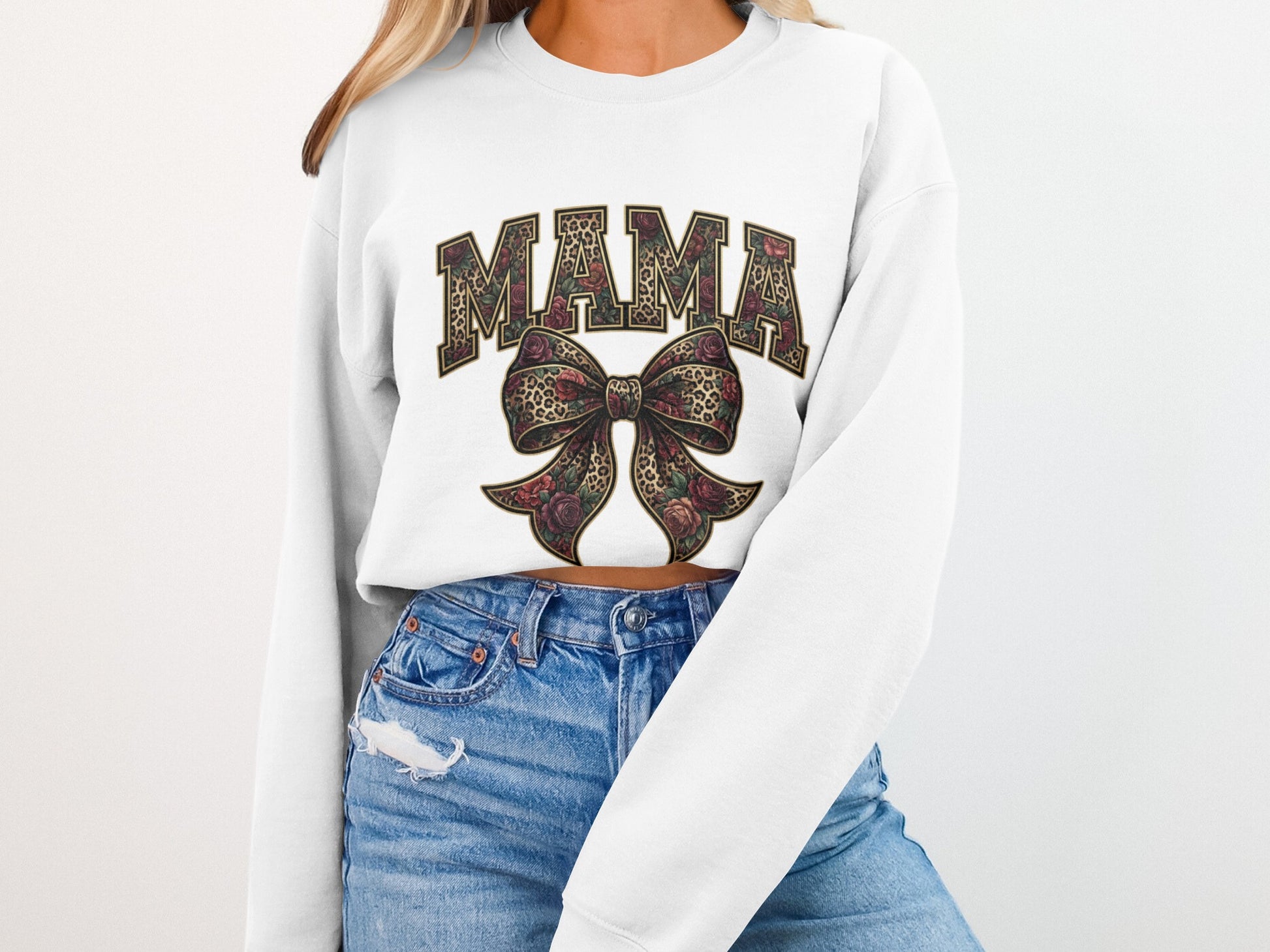 White cropped sweatshirt with "MAMA" in bold letters and a floral bow.