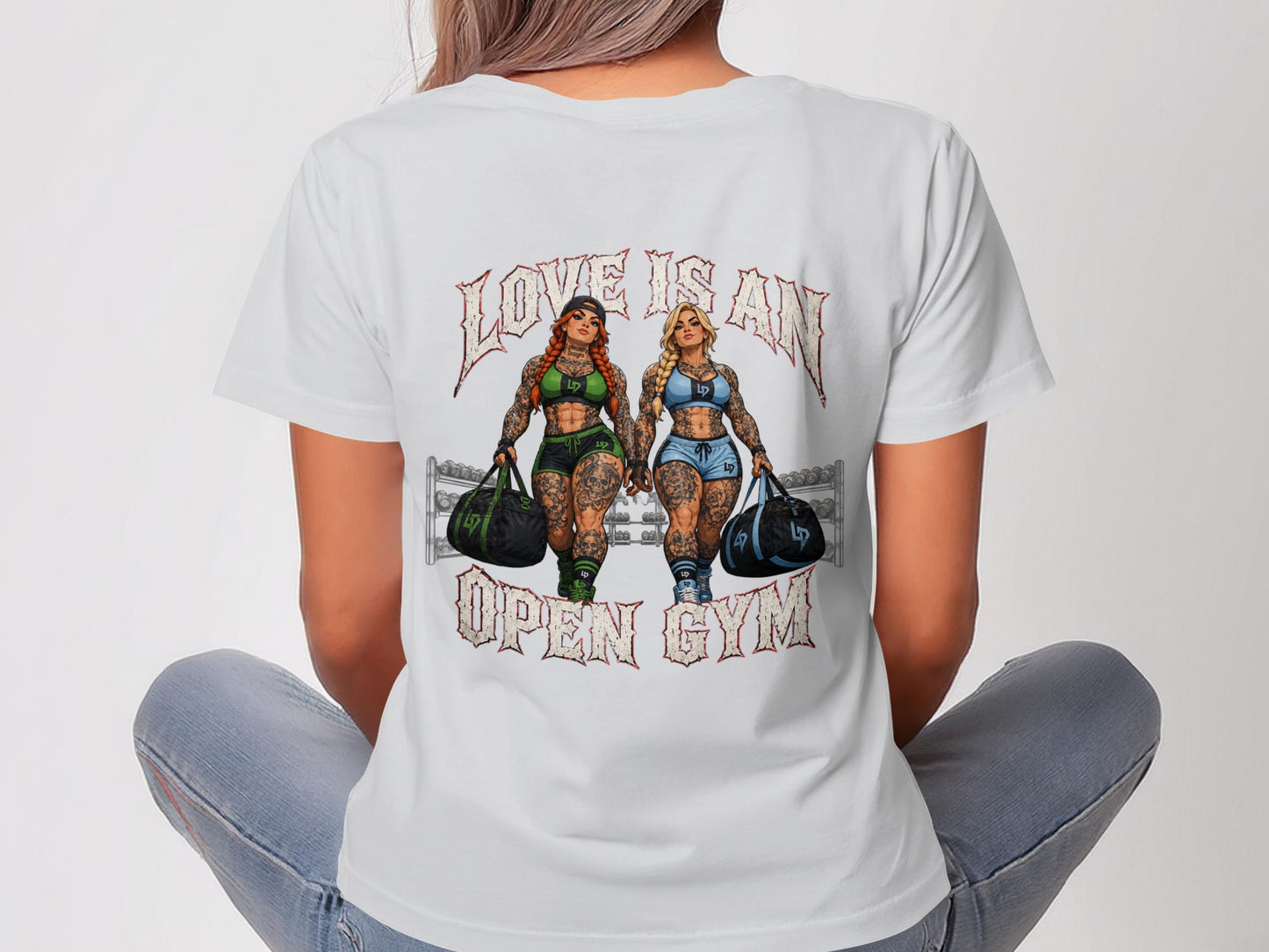 Two athletic women with tattoos and gym bags, text reads "LOVE IS AN OPEN GYM".