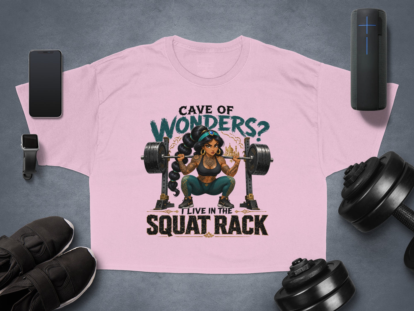 Pink t-shirt with graphic of a woman lifting weights, "Cave of Wonders? I live in the squat rack."